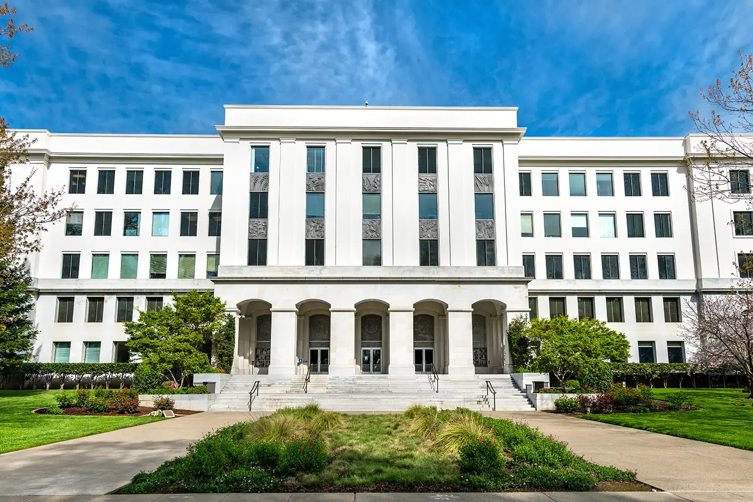 Sidewalk view of white government building